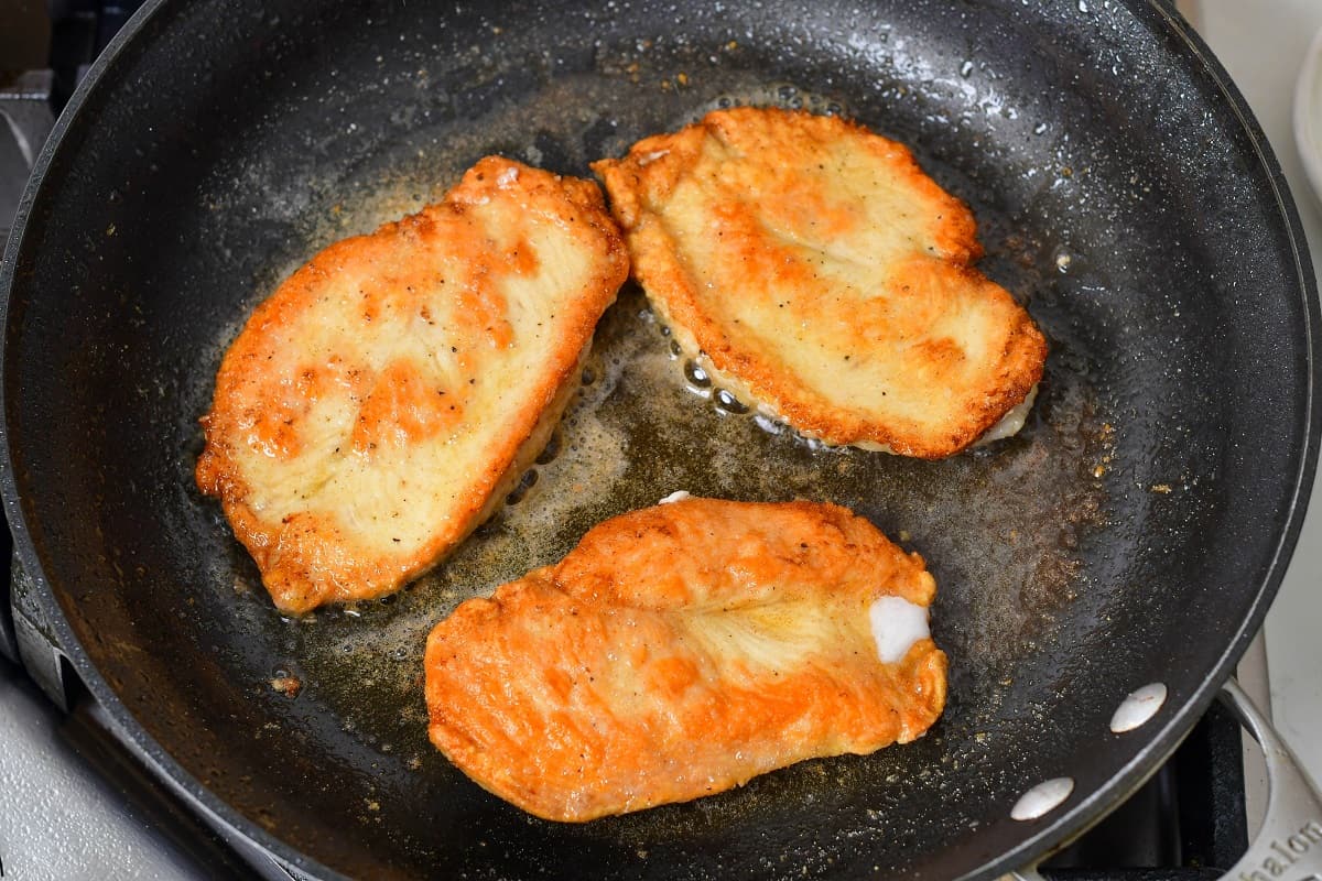 seared dredged chicken butlers in a pan