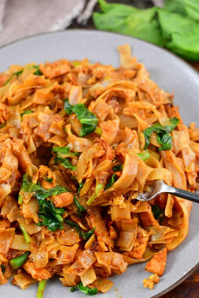 scooping some stir fried noodles with a fork