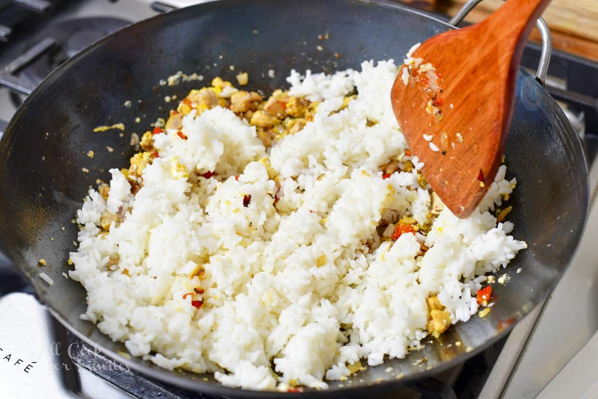 stirring cooked rice into the egg and veggies