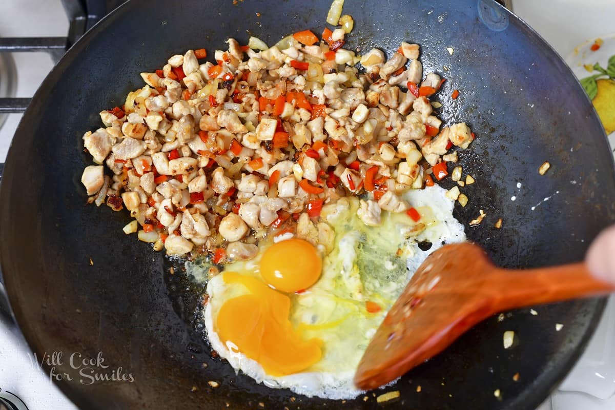 adding eggs to the work with chicken and veggies