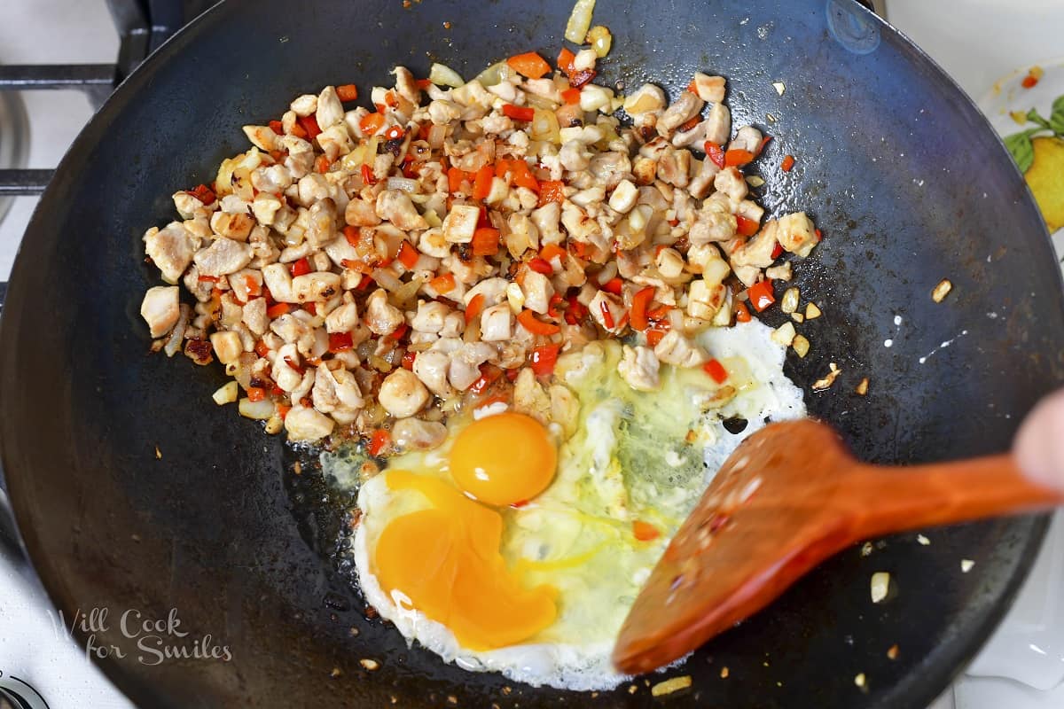 adding eggs to the work with chicken and veggies