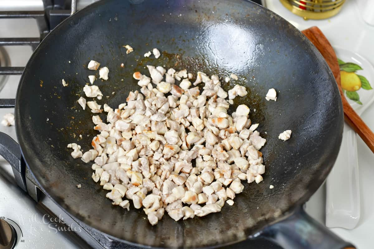 searing diced chicken in a wok