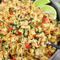 scooping out some fried rice with a fork from a deep bowl