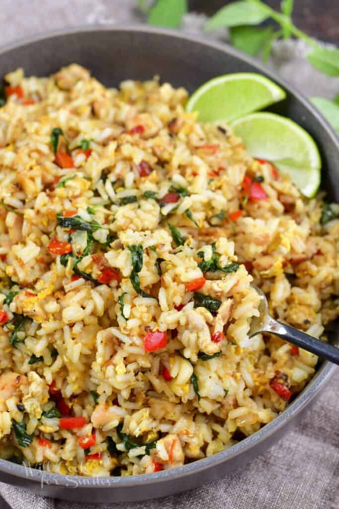 scooping out some fried rice with a fork from a deep bowl