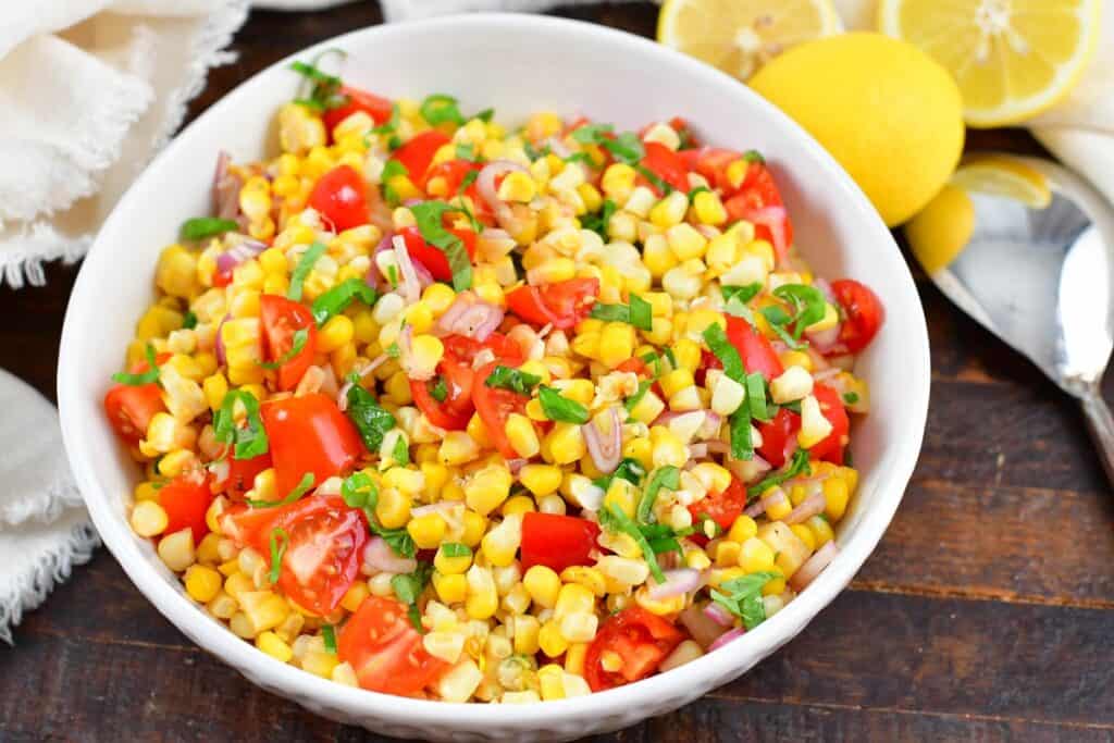 closeup of corn salad with tomatoes and basil