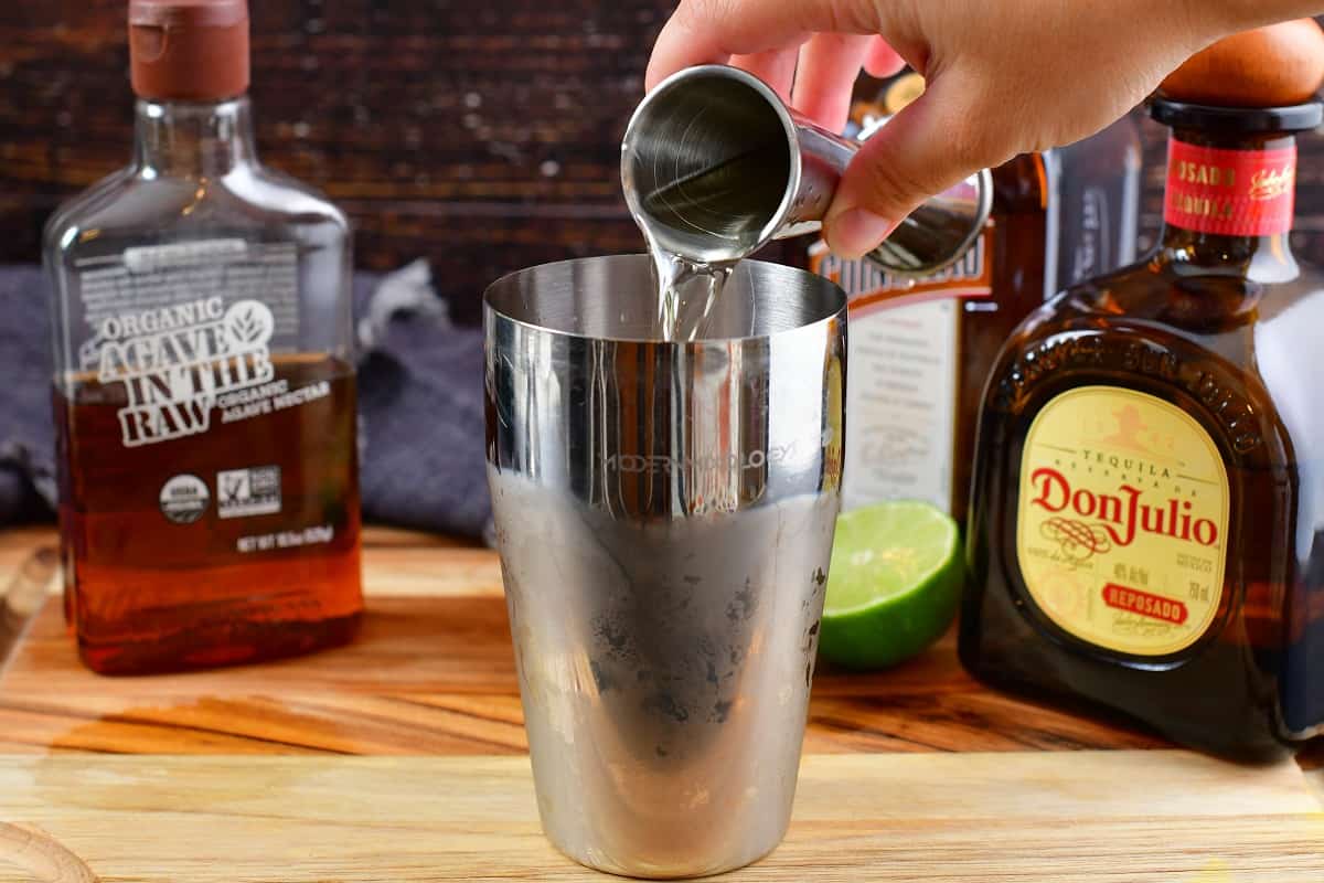 pouring the Cointreau into the cocktail shaker