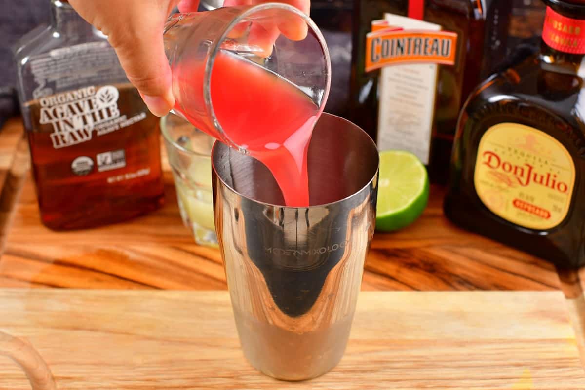 pouring the watermelon juice into the shaker