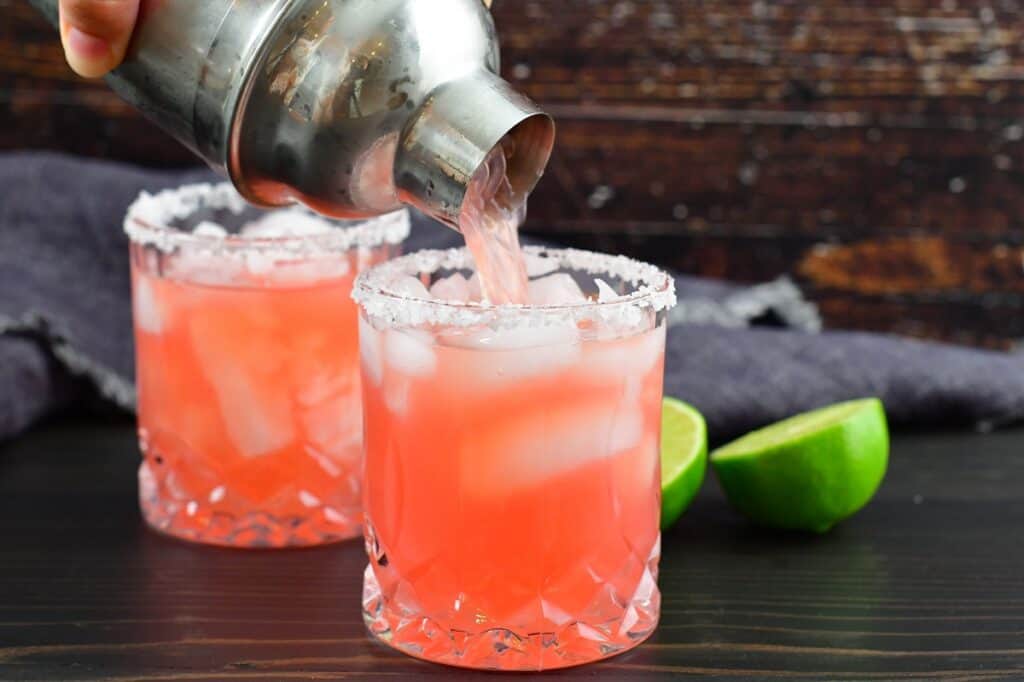 pouring the watermelon margarita into the glass
