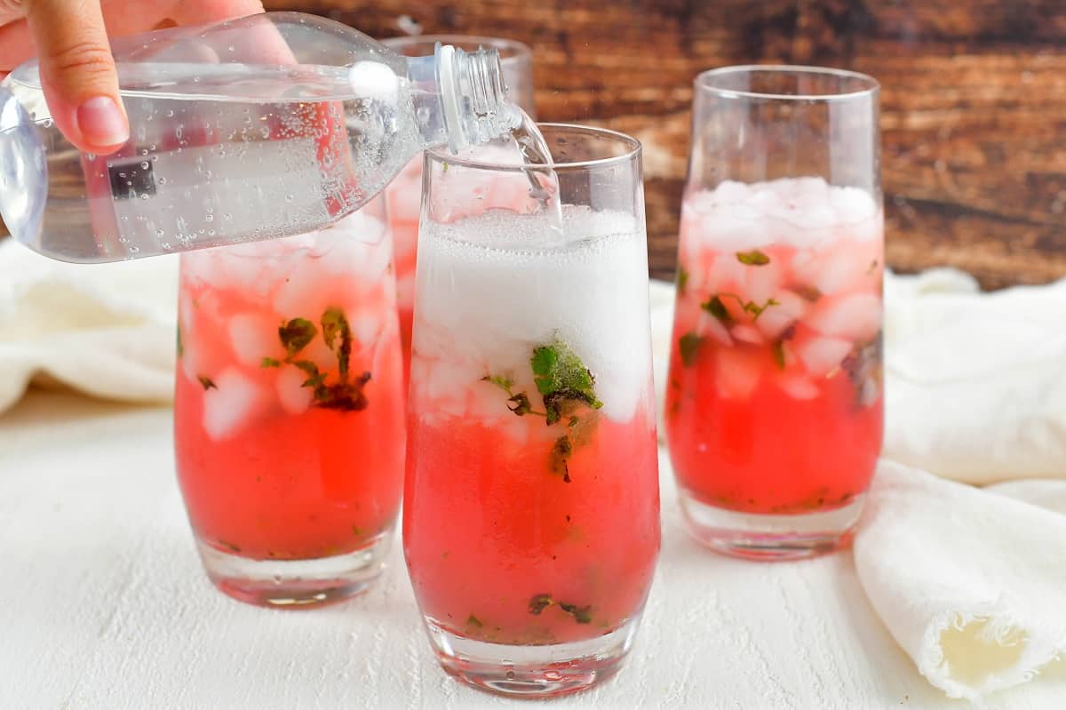 adding soda water to the watermelon mojito