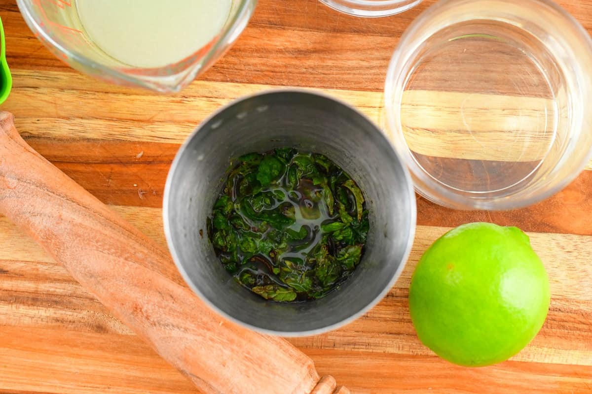 mashed mint and lime juice in a shaker