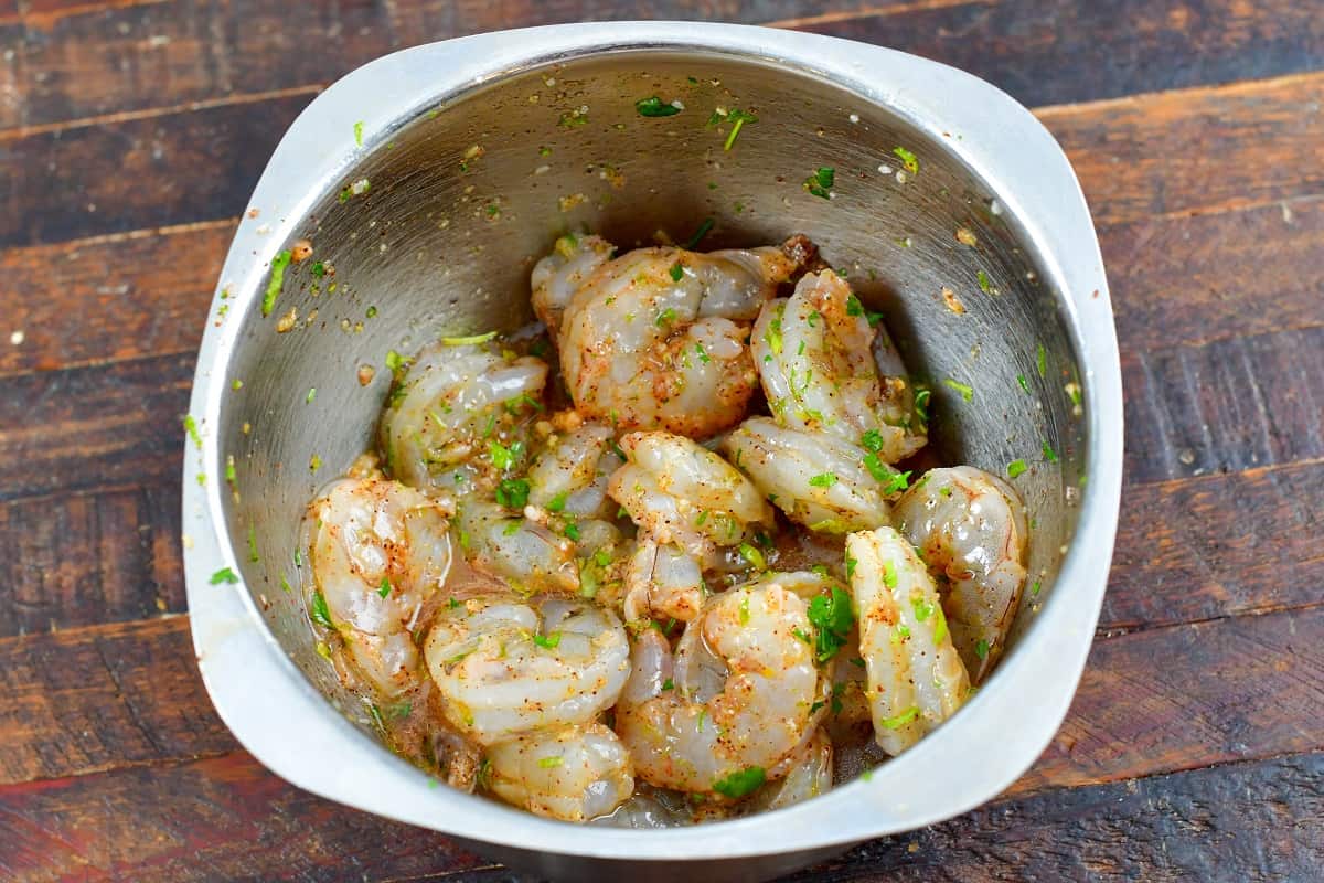 shrimp mixed with marinade in a mixing bowl