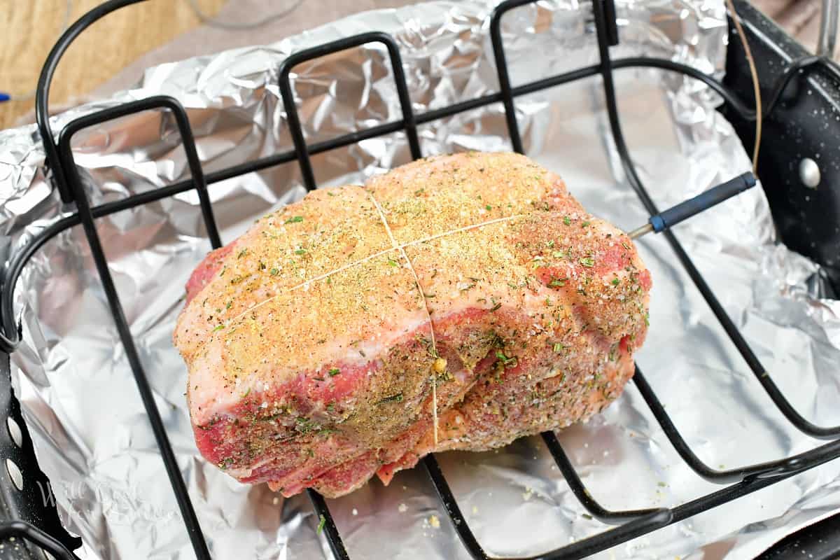 seasoned and tied pork shoulder in the roasting pan.