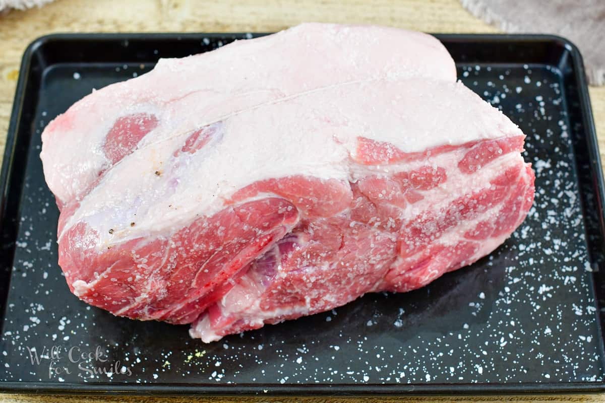 pork shoulder salted and tied on the baking sheet.