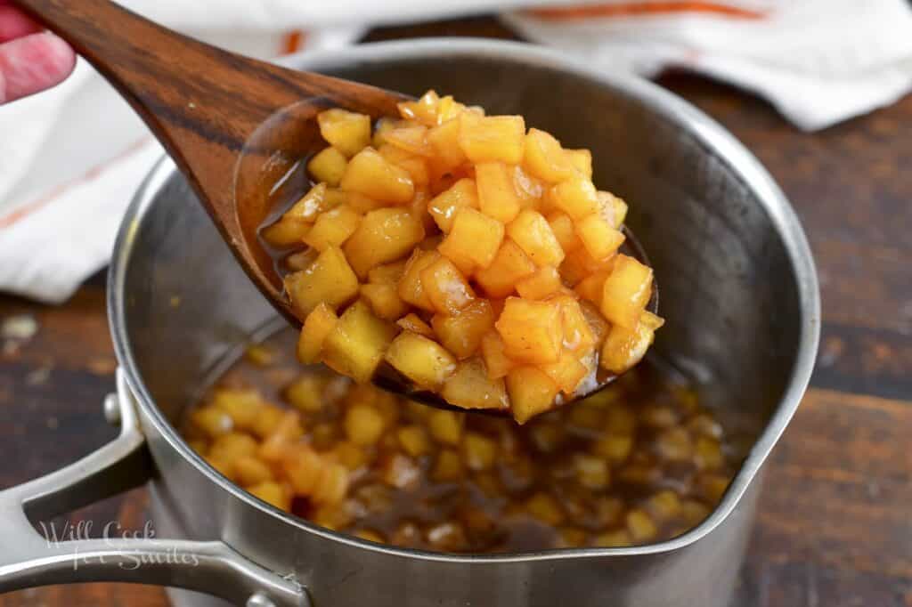 scooping out apple pancake topping with a spoon