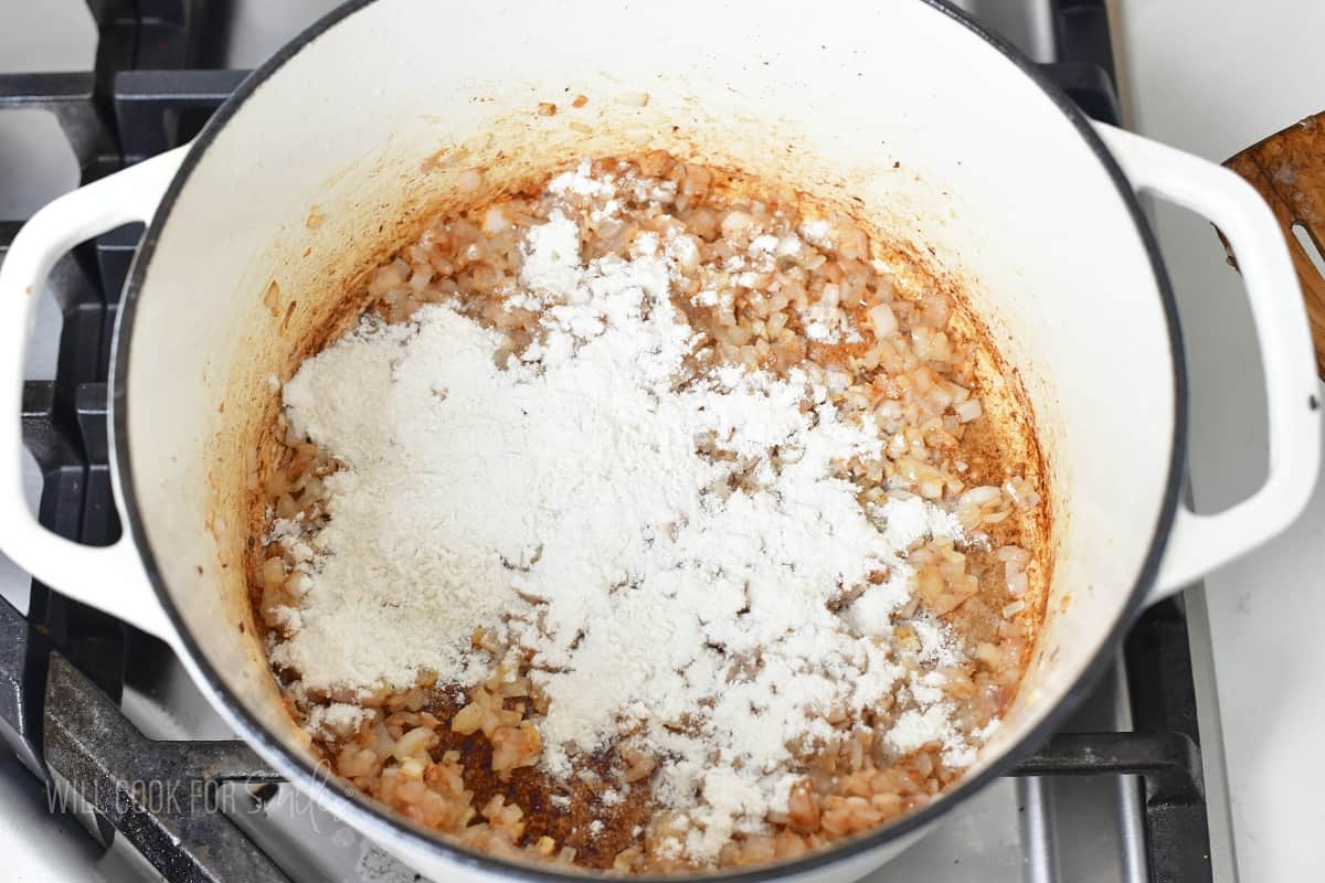 spreading flour over the sautéed onions.