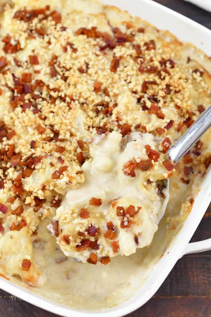 scooping out some cauliflower casserole with a spoon.