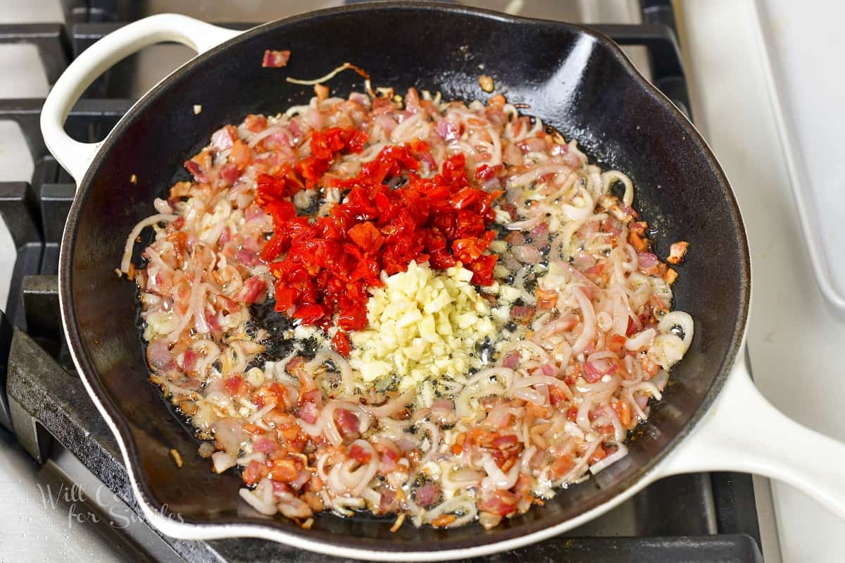 adding sun dried tomatoes and garlic to the onions