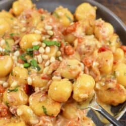 scooping some creamy gnocchi from the plate