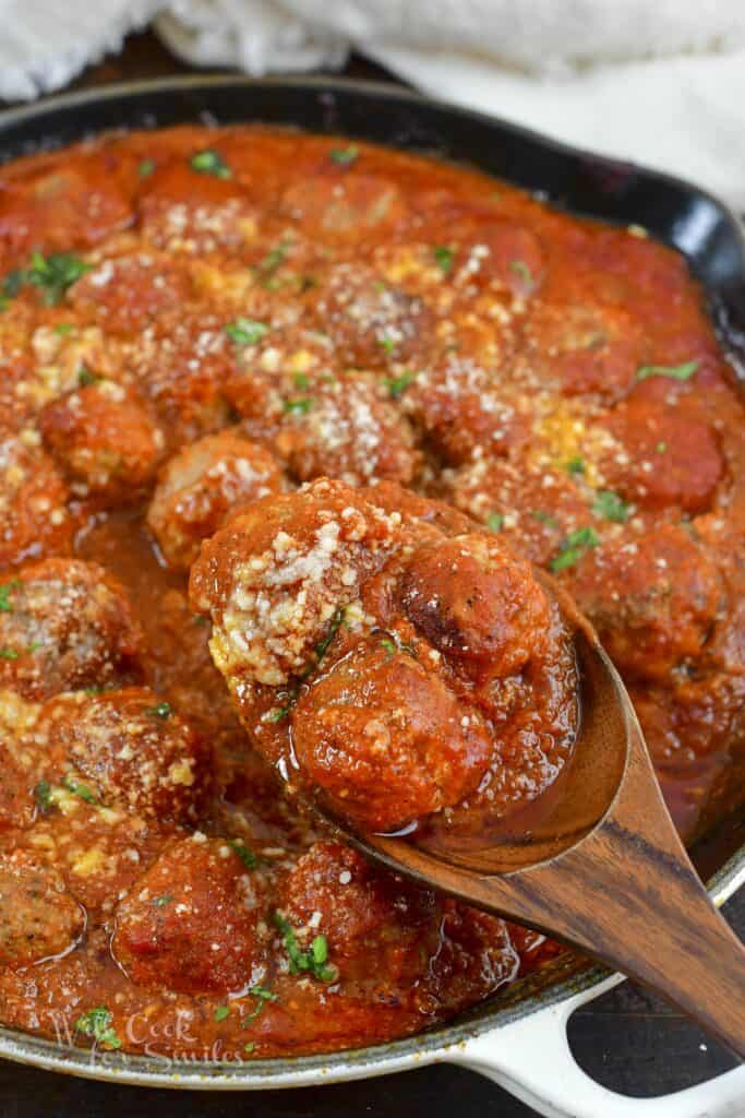 scooping out some Italian meatballs in sauce