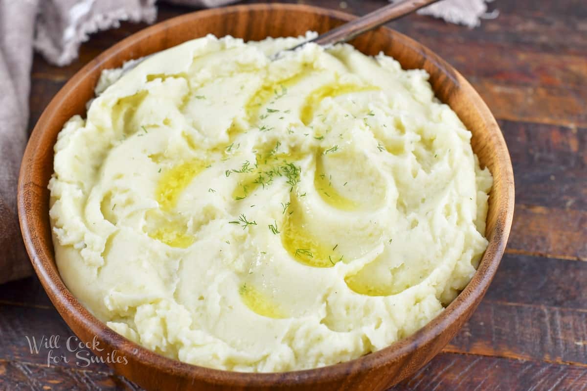 closeup mashed potatoes in a wooden bowl.