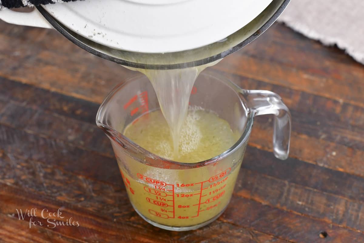 separating some cooking water into the measuring cup.