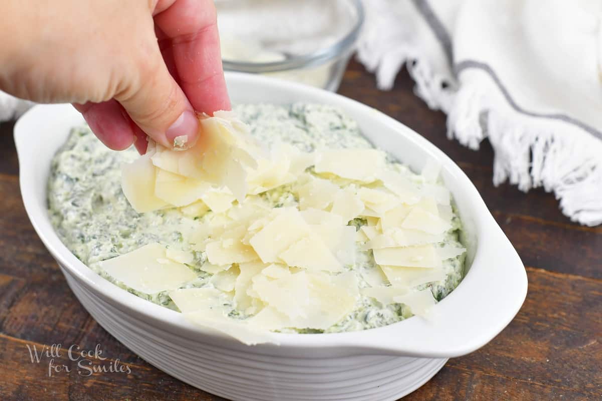 spreading some shaved Parmesan dip over the dip mixture.