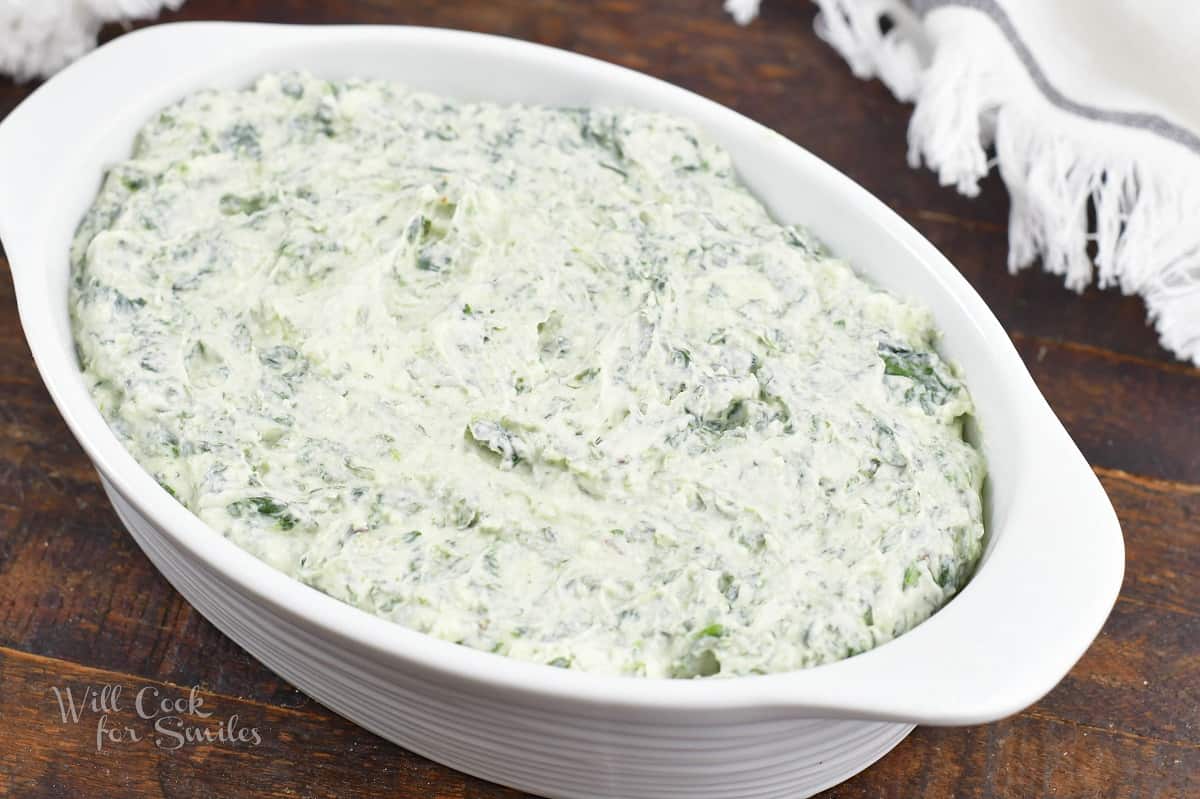 spinach dip mixture spread in a baking dish.