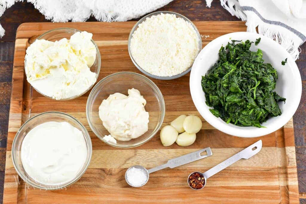 Ingredients for the spinach dip on the cutting board.