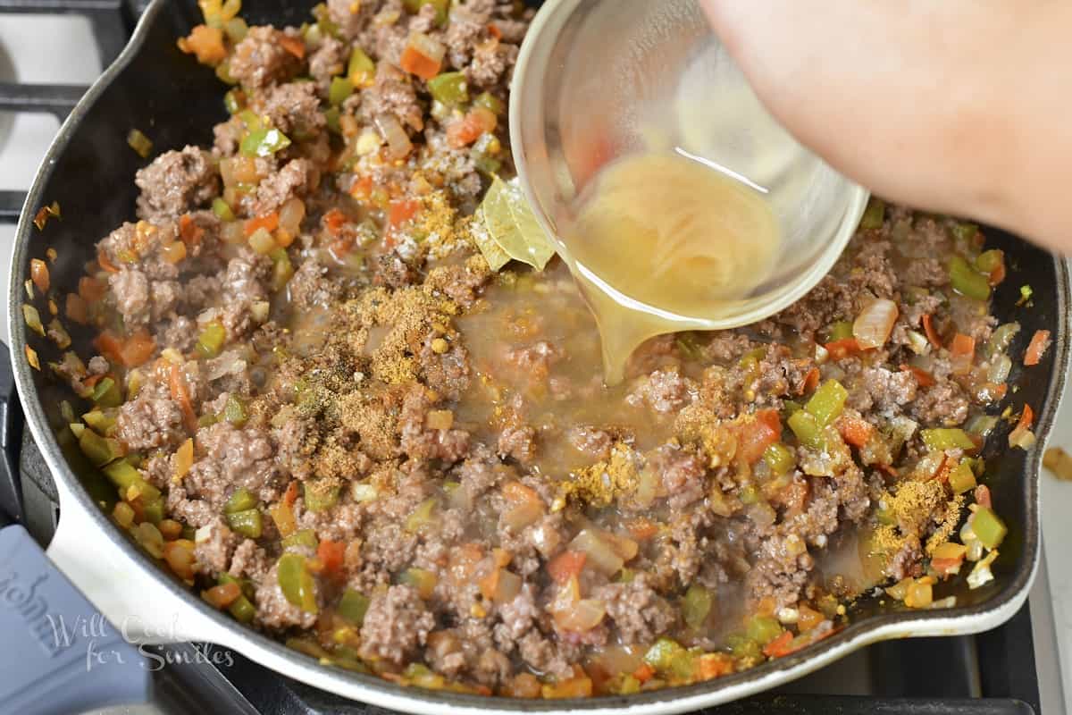 adding stock to the pan with ground beef and vegetables