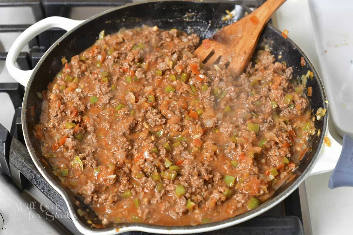 beef and vegetables simmering in sauce in the pan