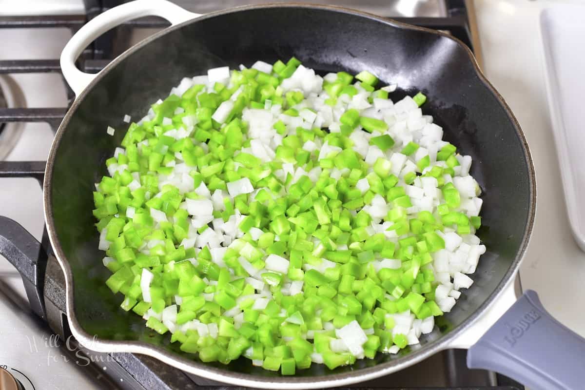 diced onions and green peppers cooking in the pan