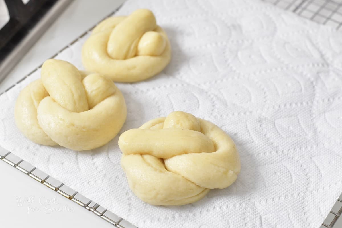 three boiled pretzels on paper towel.