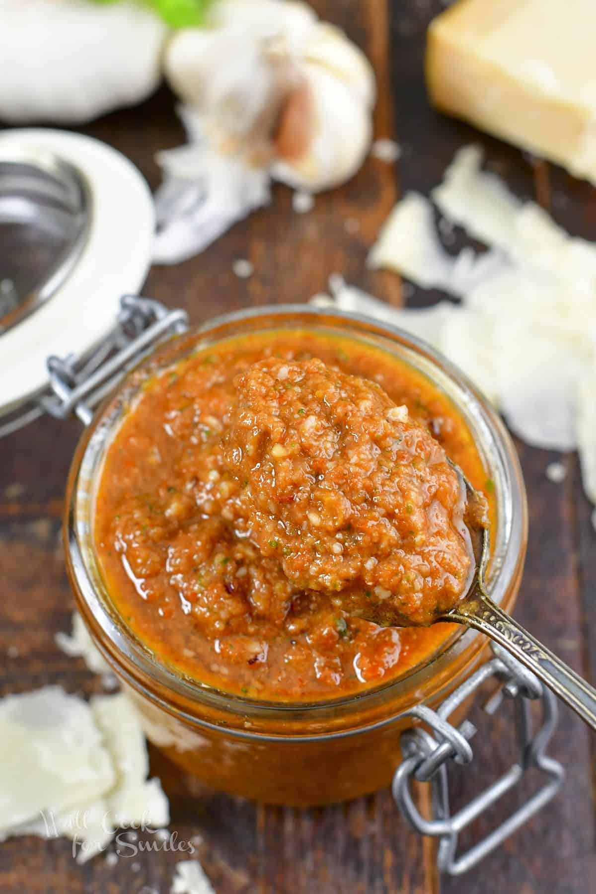 scooping out some pesto rosso from the jar