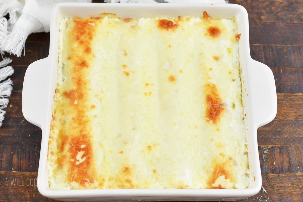 baked creamy enchiladas in a white dish.