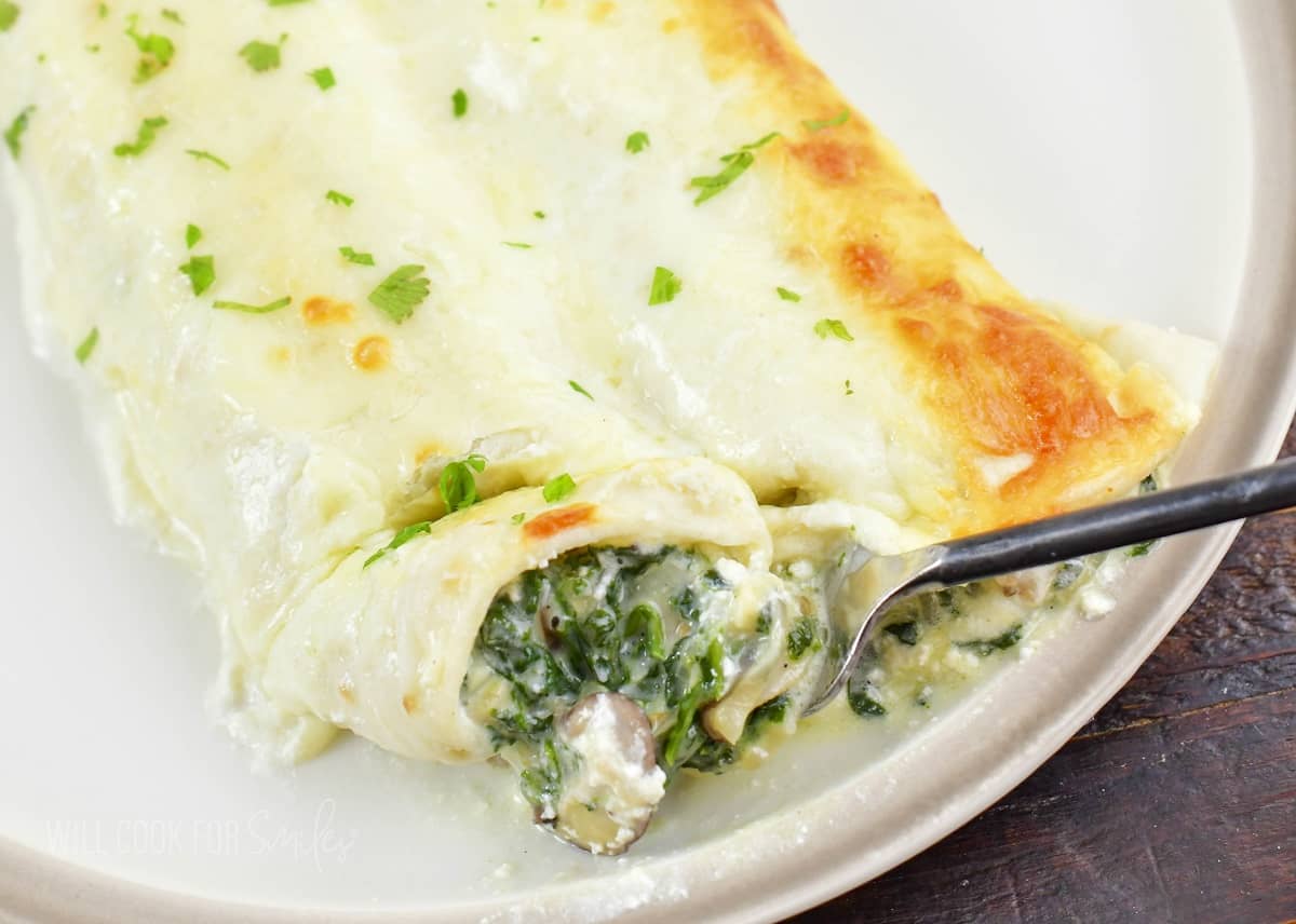 closeup of cut enchilada on a fork.