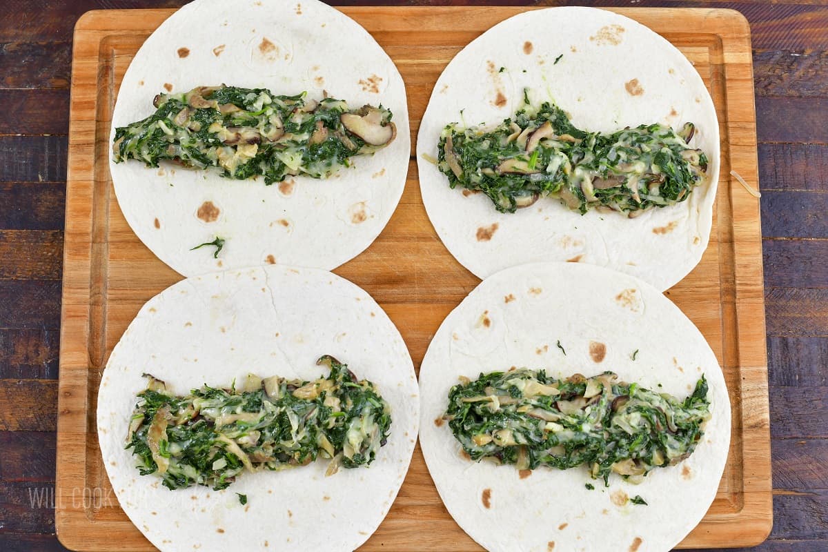 four tortillas with spinach filling spread in each.