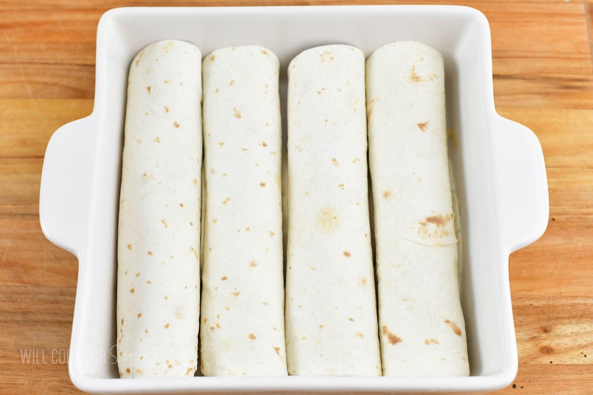 four rolled enchiladas in the white baking dish.