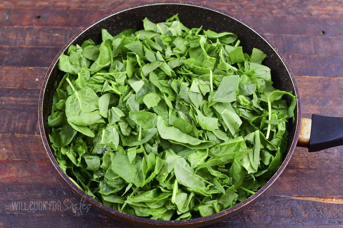 chopped spinach in a large cooking pan.