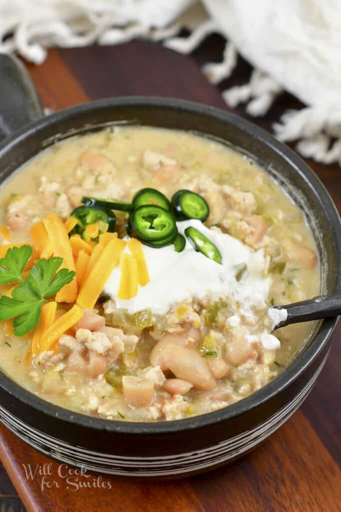 spooning out some turkey chili out of a bowl