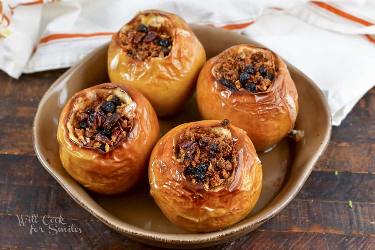 four baked apples baked in a ceramic dish