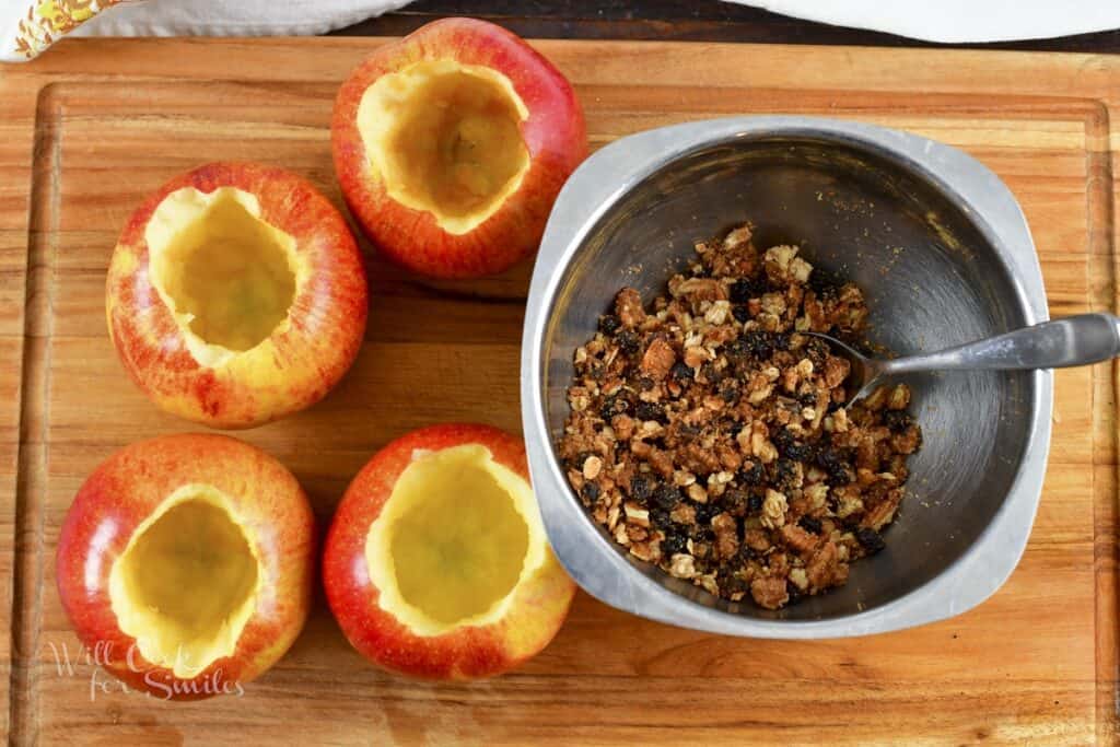 four scooped apples and apple filling in a bowl