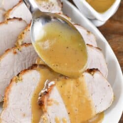 spreading gravy over the sliced pork.