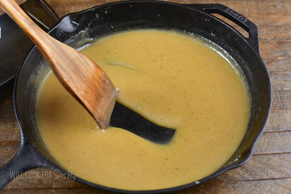 stirring pan drippings gravy in a skillet.