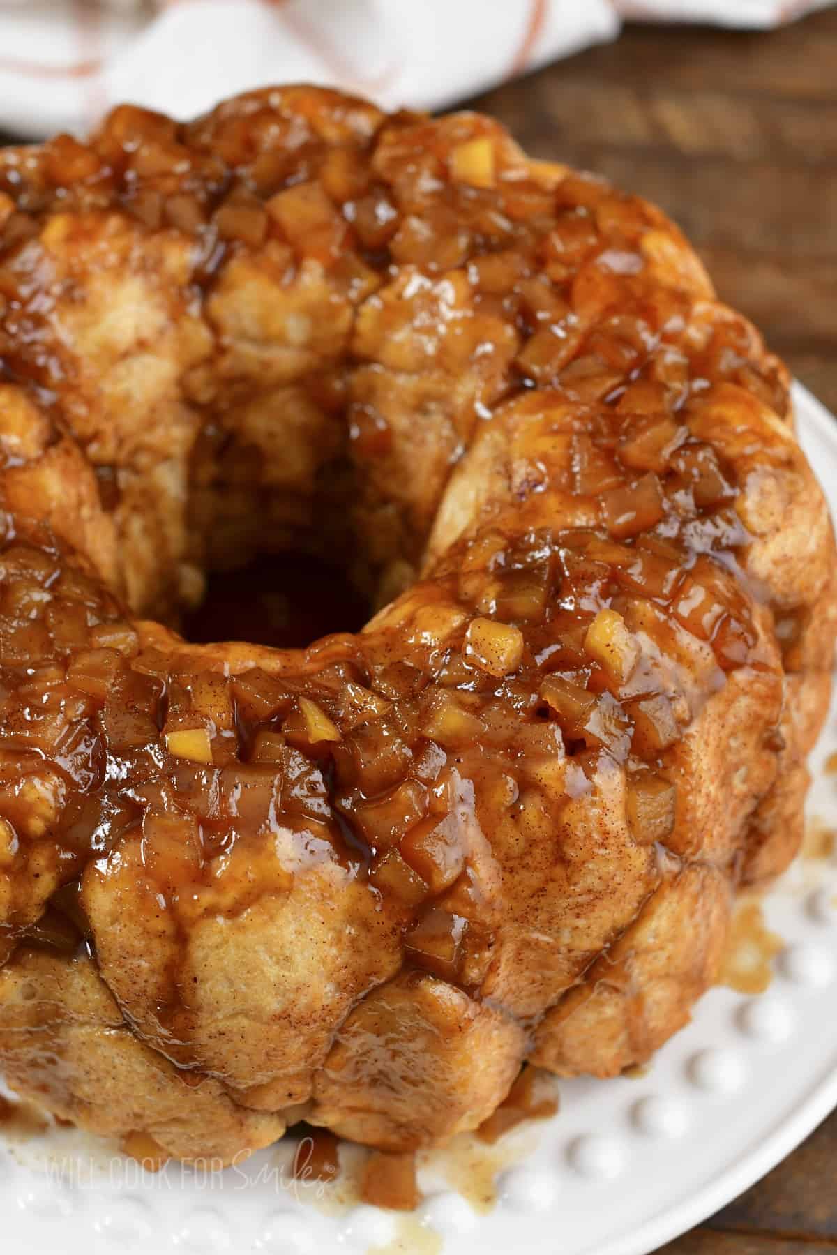 closeup of apple monkey bread on white dish.