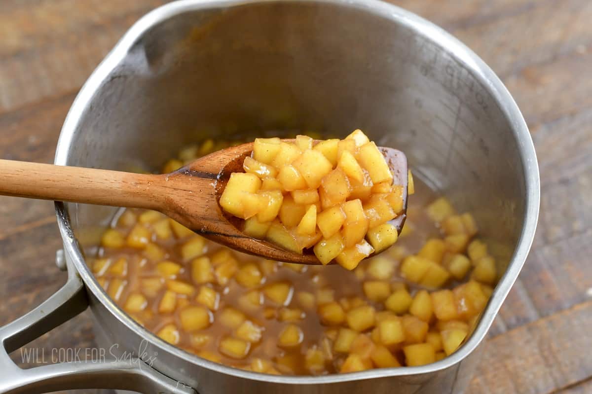 scooping out some cooked apples for apple pie topping.