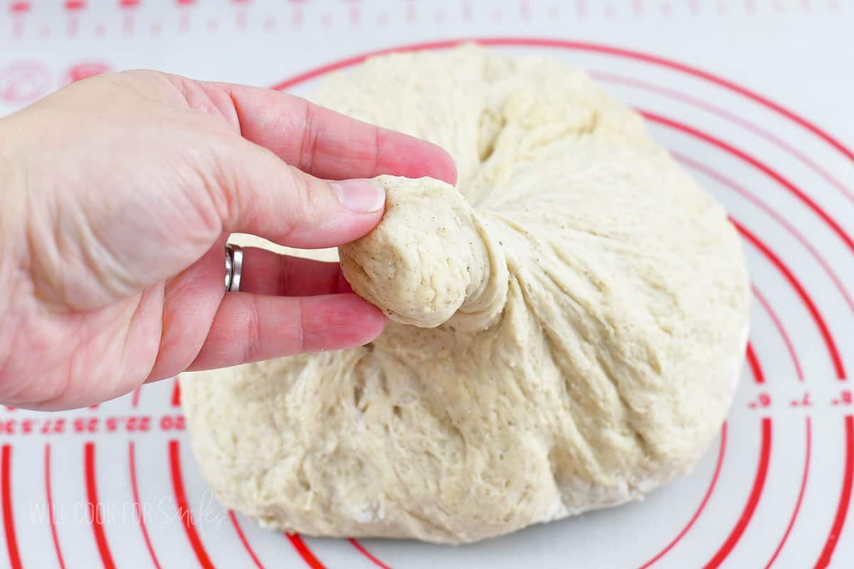 pulling off a piece of dough.