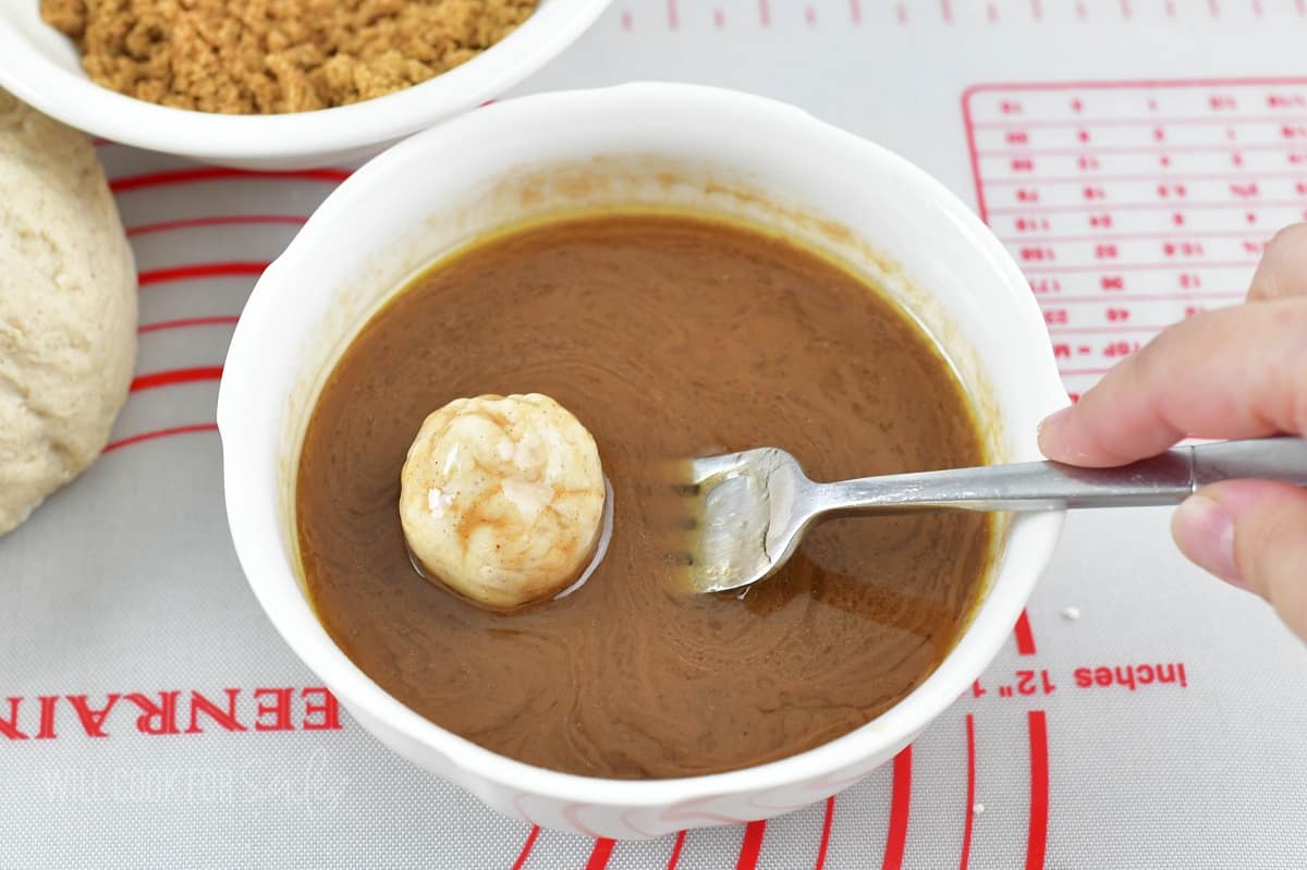 rolling a dough ball in apple pie sauce.