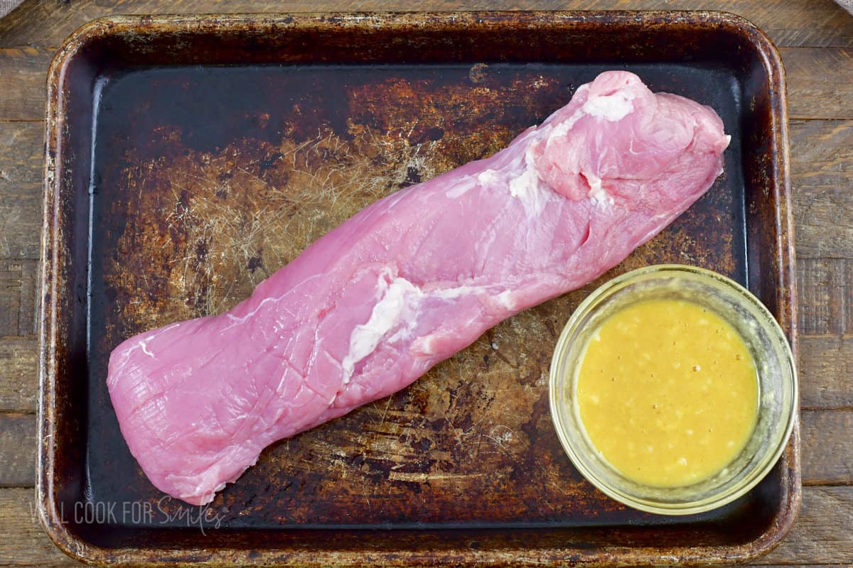pork tenderloin next to honey mustard sauce.