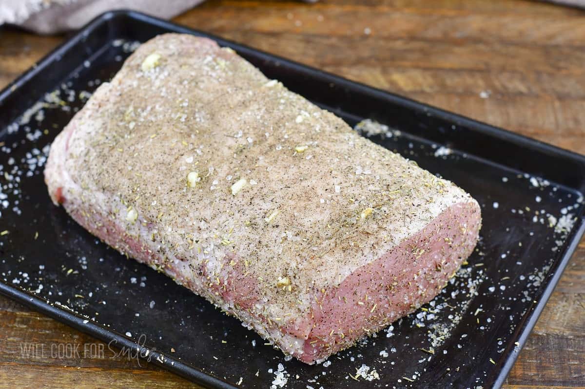 seasoned pork loin in a baking sheet.