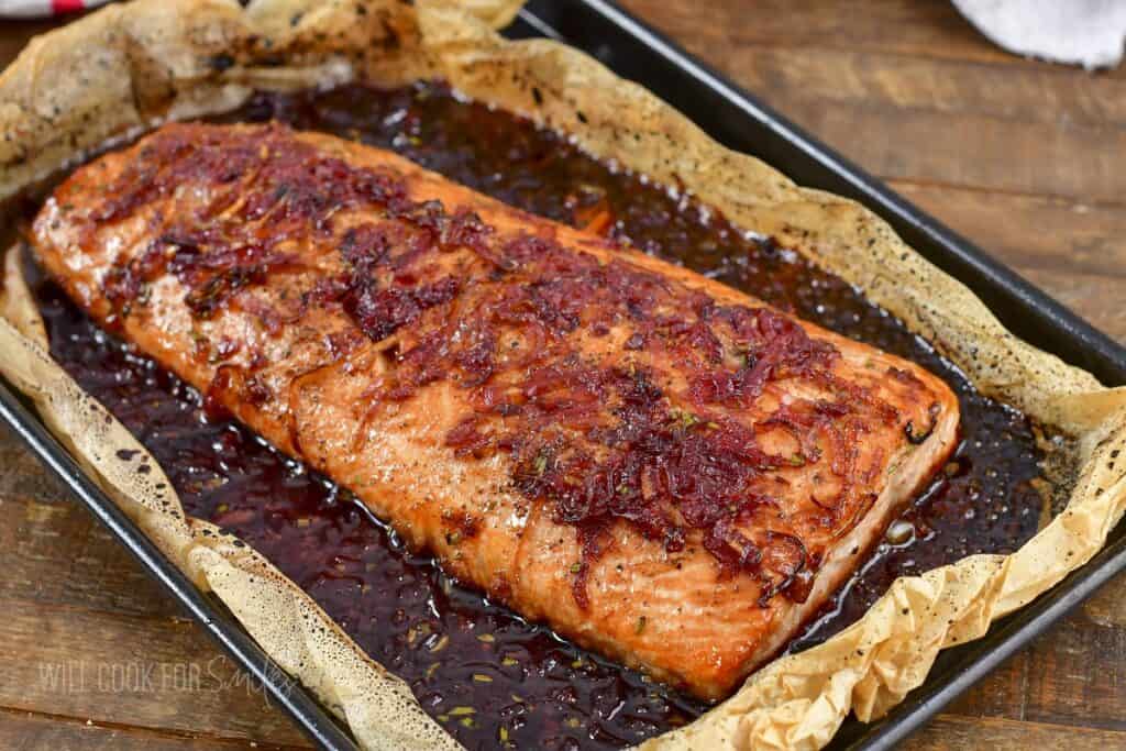 baked salmon filet in the baking sheet in sauce.